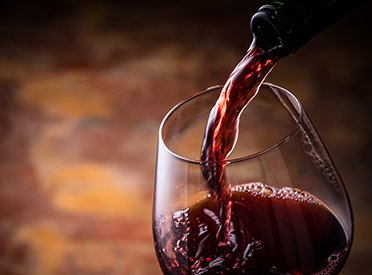 Weinglas in das Rotwein gegossen wird